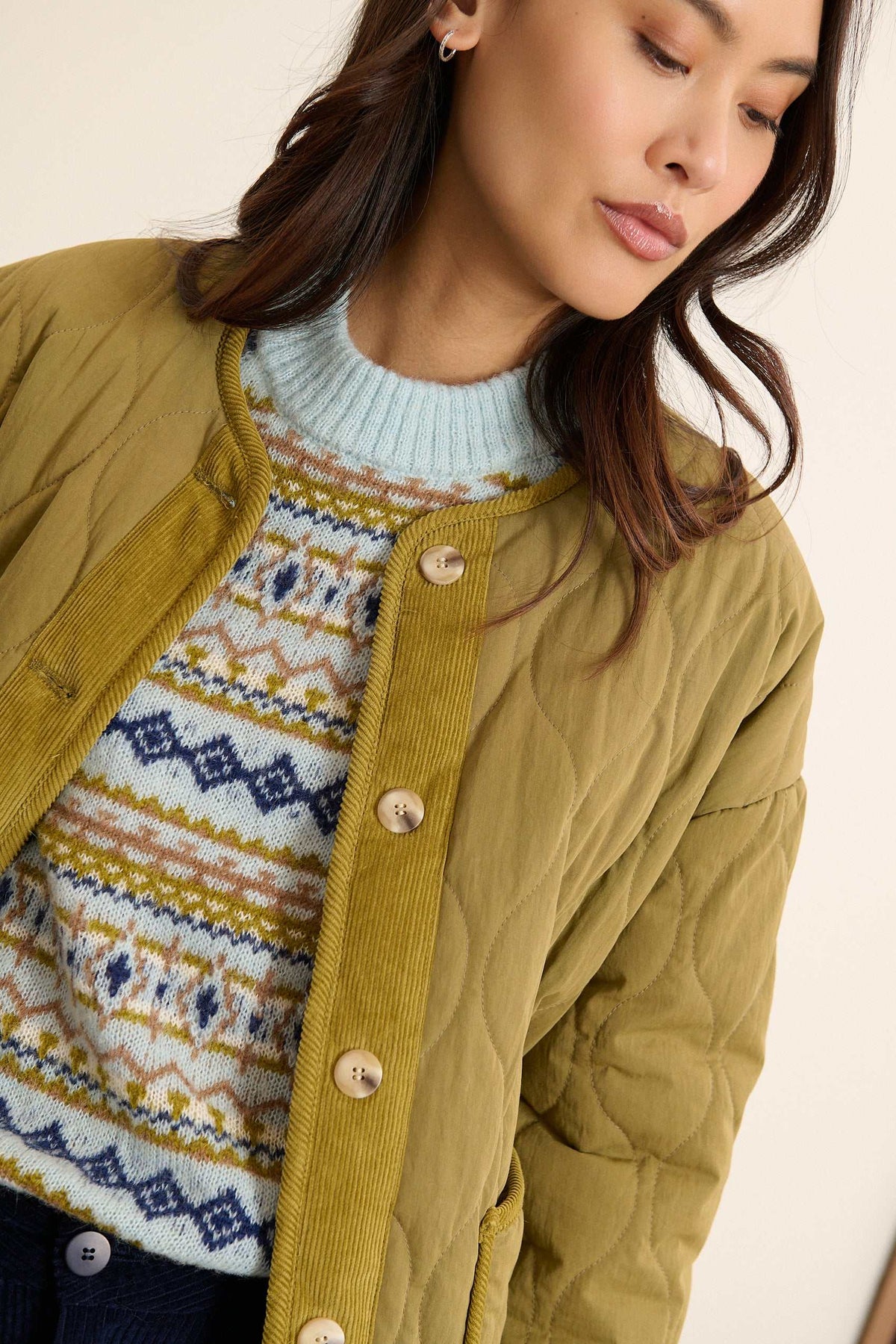 Manteau court réversible avec emmanchures souples et tombé naturel sur l'épaule, coloris kaki.