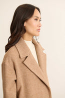 Vue de profil du manteau TRAVIS coloris beige Garance avec focus sur le col tailleur et détails du double boutonnage. 