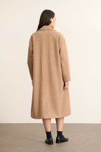 Vue de dos du manteau TRAVIS beige, composé d'une fente discrète en bas du dos et d'une coupe droite élégante. 