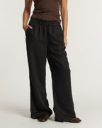 Pantalon large en tissu fluide noir avec taille élastiquée, coupe droite décontractée offrant confort et élégance, idéal pour un style femme polyvalent.