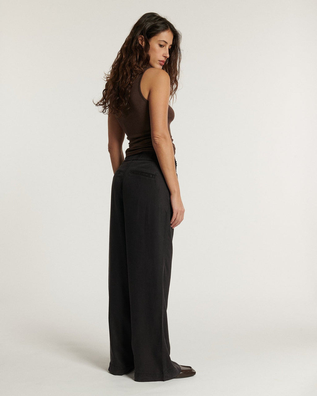 Jean marron foncé en tissu Tencel fluide, coupe large et droite, offrant un confort léger et une silhouette élégante adaptée à toutes les morphologies.