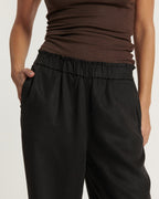 Jean noir en tissu léger et fluide avec taille élastiquée et coupe droite confortable, idéal pour s’adapter à toutes les morphologies féminines.
