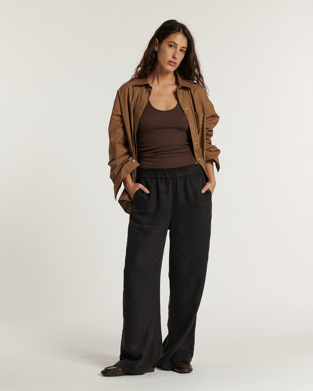 Pantalon large pour femme en tissu fluide marron foncé, coupe décontractée avec taille élastique pour un confort optimal adapté à toutes les morphologies.