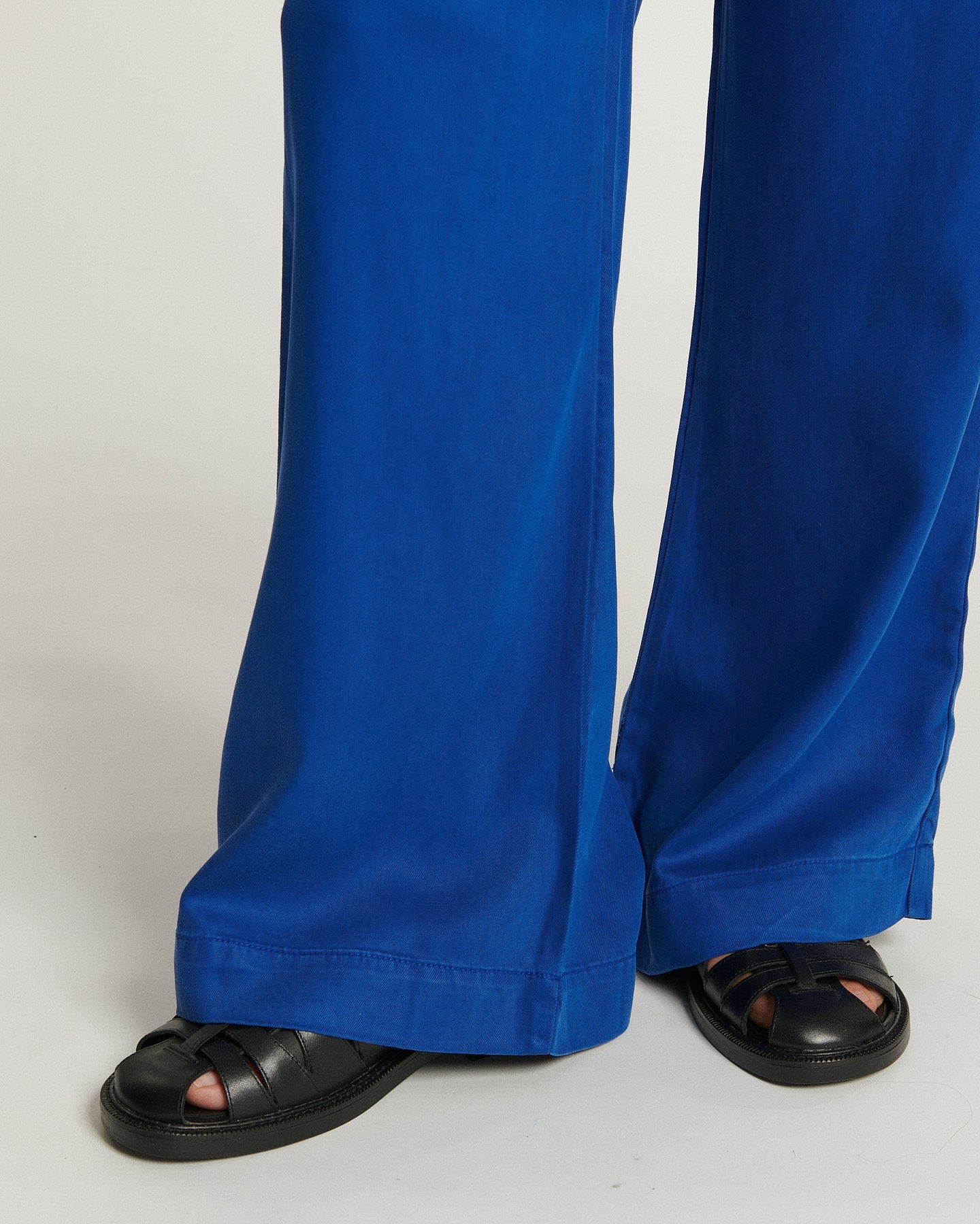 Jean femme en tissu tencel bleu outremer, coupe large et fluide, légèrement évasée au bas, offrant un confort estival et un style décontracté élégant.