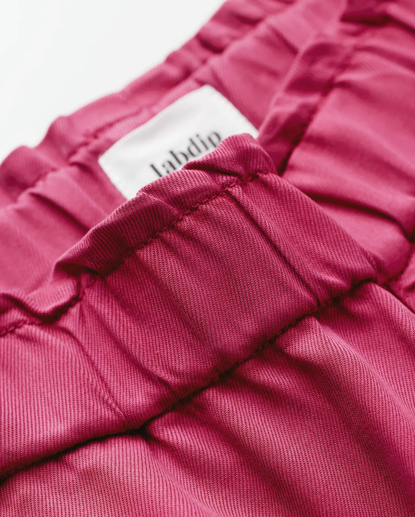 Jean femme en tissu Tencel rouge cerise, coupe ajustée avec taille élastique, matière douce et légère idéale pour un pantalon confortable et élégant.