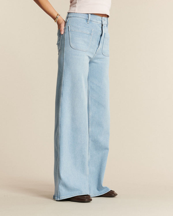 Light blue cotton denim jeans, wide and fluid cut, offering a loose and comfortable fit suitable for all female body shapes.