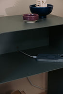 Stehender Nachttisch mit minimalistischem Design, Ladeschale und dekorativen Schalen auf der Ablage.