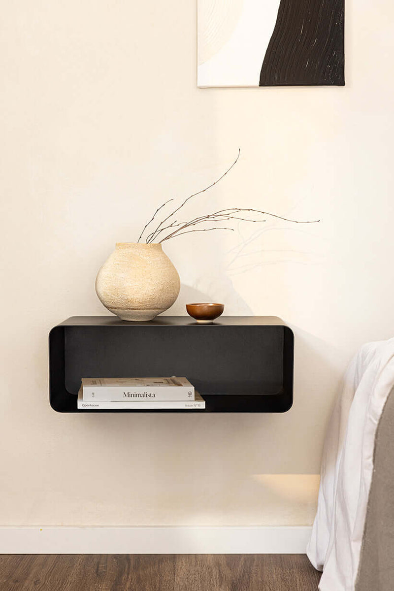 Hängender Nachttisch NELIO mit minimalistischer Formgebung und decorativem Zubehör an einer Wand.