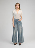 An'ge – Pantalon Palide Bleu, mannequin portant un haut blanc cassé et un jean large bleu