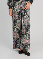 An'ge – Pantalon Passyna Noir, pantalon large fleuri noir, rose et vert porté de face