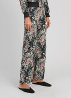 An'ge – Pantalon Passyna Noir, pantalon large fleuri noir, rose et vert, porté de profil