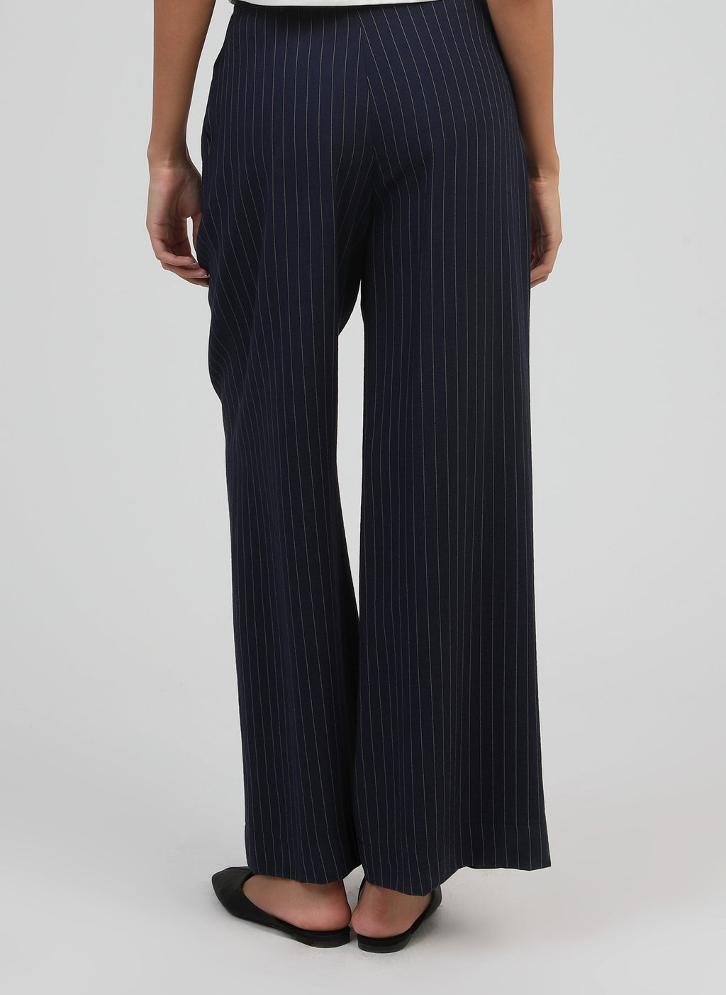 An'ge – Hose Patila Marine, weite marineblaue Hose mit feinen weißen Streifen, von hinten getragen