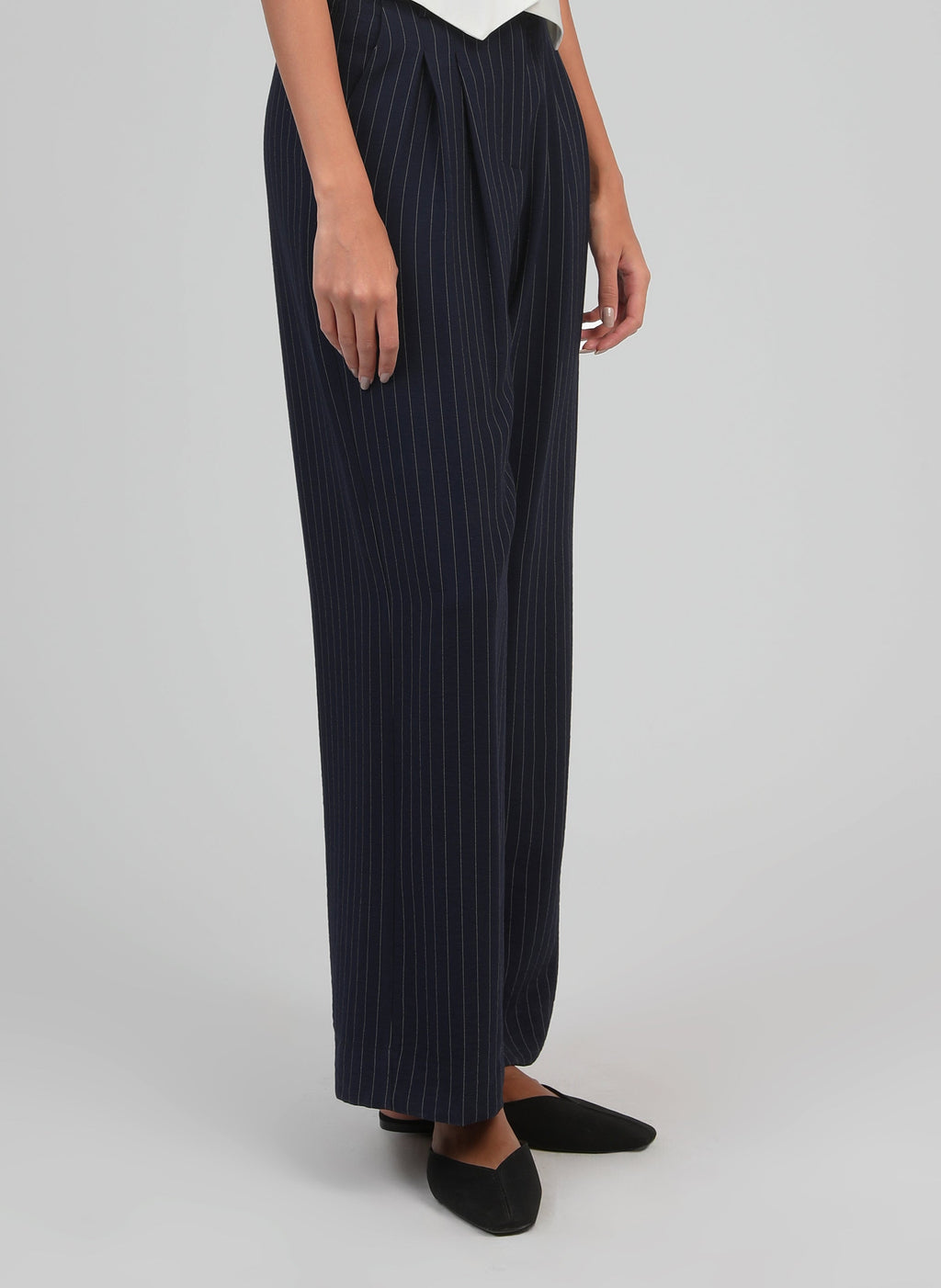 An'ge – Hose Patila Marine, weite marineblaue Hose mit feinen weißen Streifen an einem Model