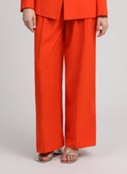 An'ge – Hose Pepy Piment, weite Hose in leuchtendem Orange, von einem Model getragen, Vorderansicht