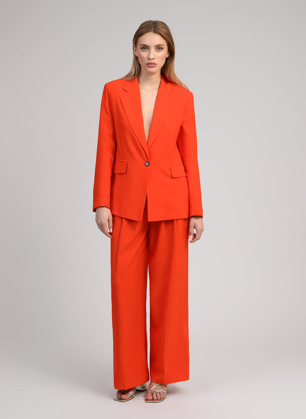An'ge – Hose Pepy Piment, Model in Kombination aus Blazer und weiter Hose in leuchtendem Orange, Vorderansicht