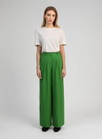 An'ge – Pantalon Pepy Pomme, mannequin portant un t-shirt blanc et un pantalon vert ample, vue de face