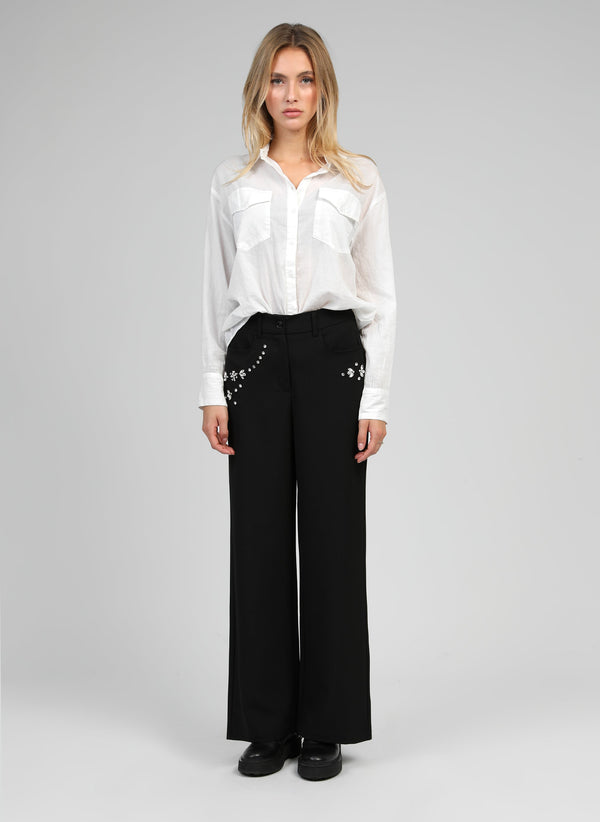 An'ge – Pantaloni Perdina Noir, modella donna bionda con camicia bianca e pantaloni neri