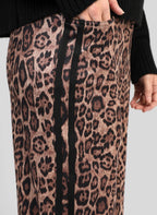 An'ge – Pantalon Perleo Noir, gros plan sur un pantalon à motif léopard avec une bande noire latérale