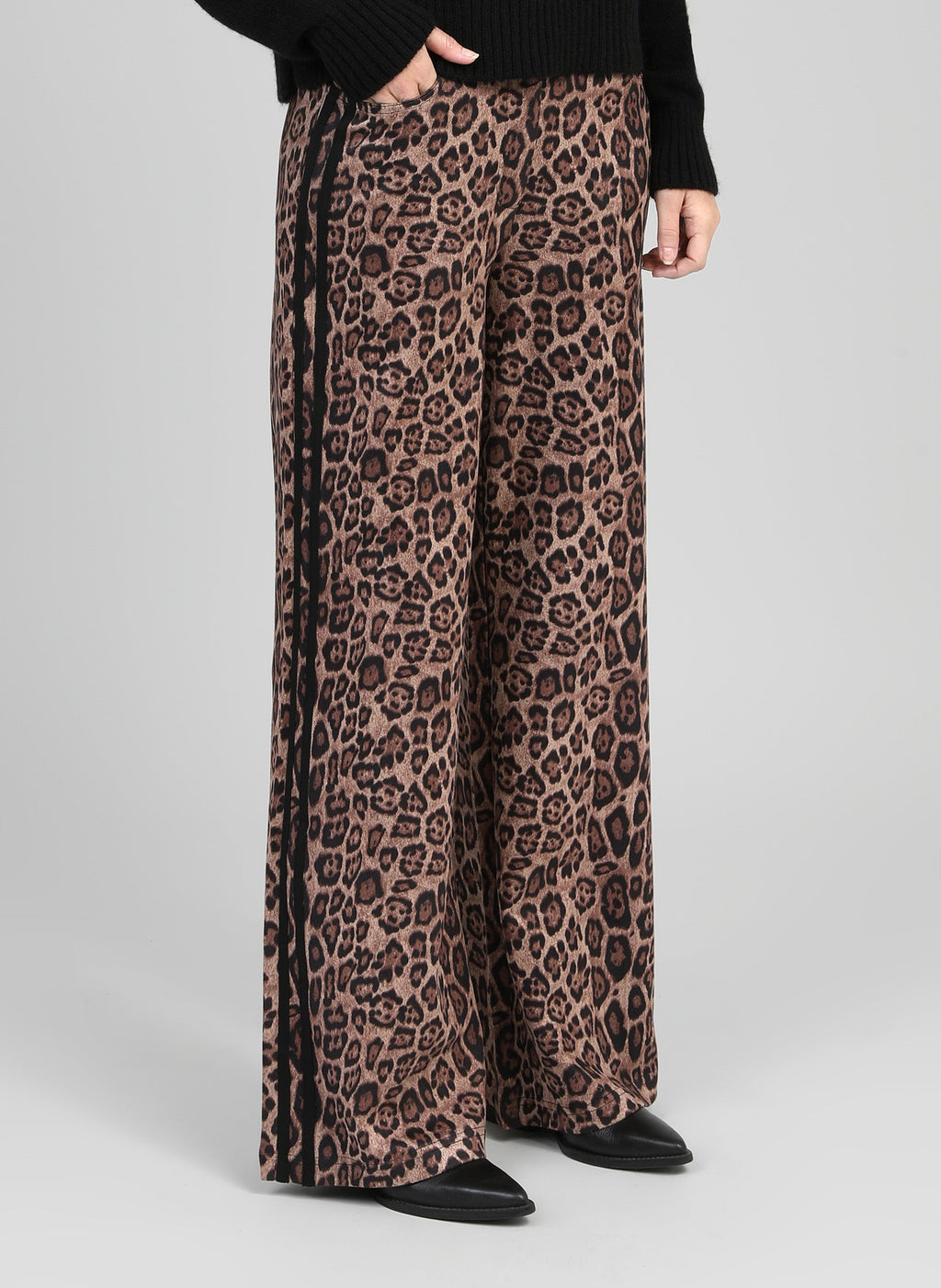 An'ge – Pantalon Perleo Noir, pantalon large imprimé léopard avec bande latérale noire, porté par un mannequin