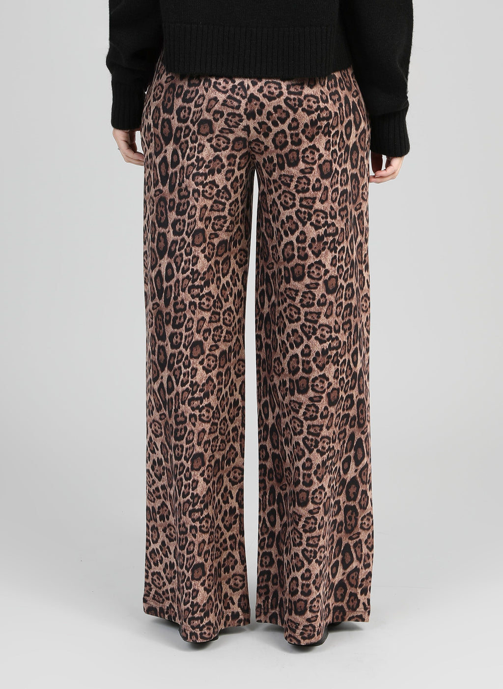 An'ge – Pantalon Perleo Noir, pantalon large à imprimé léopard marron et noir, porté de dos