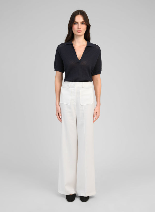 An'ge – Broek Philizia Wit, vrouwelijk model in een marineblauwe polo en een witte broek