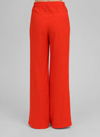 An'ge – Pantalon Philizia Piment, pantalon large rouge vif porté de dos par un mannequin