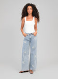 An'ge – Pantalón Pafli Azul, modelo mujer vista de frente, top blanco y vaquero azul claro