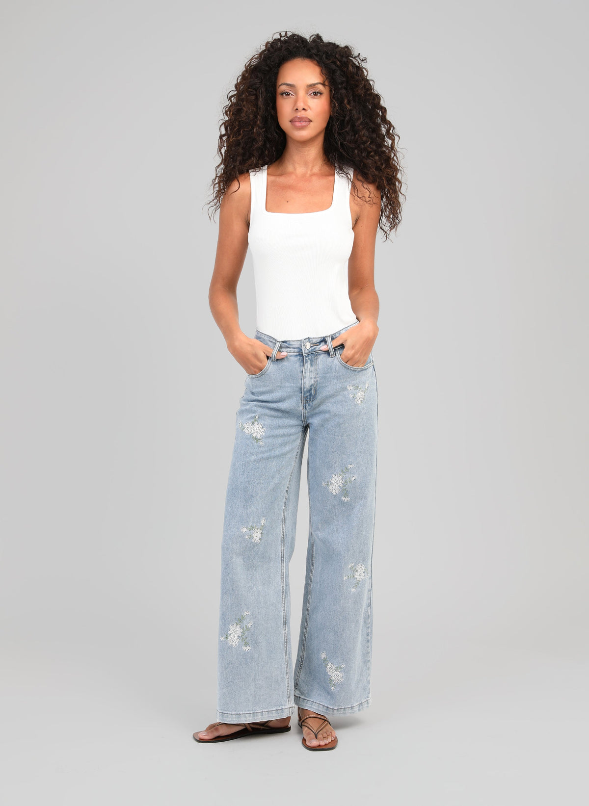 An'ge – Pantalón Pafli Azul, modelo mujer vista de frente, top blanco y vaquero azul claro