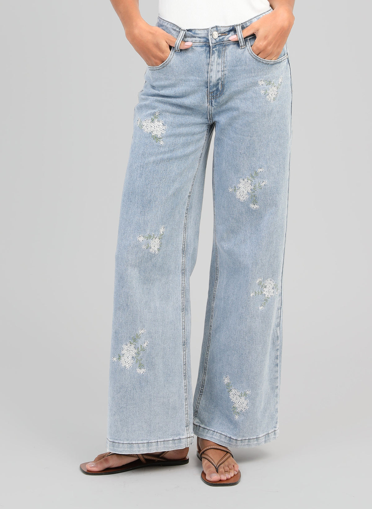 An'ge – Pantalón Pafli Azul, vaquero ancho azul claro bordado con flores blancas, visto de frente
