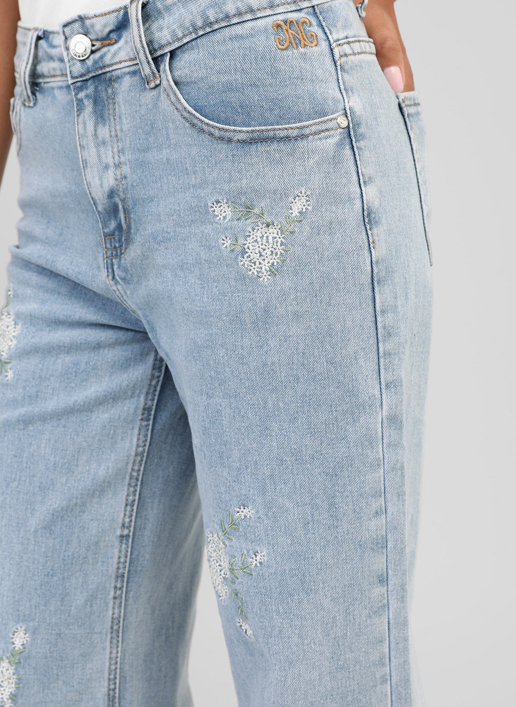 An'ge – Pantalón Pafli Azul, vaquero azul claro bordado con flores blancas, llevado por una modelo