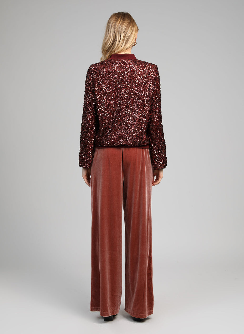 An'ge – Pantalon Pontalene Rose, model set bagfra iført en bordeaux paillettop og fløjlsbukser