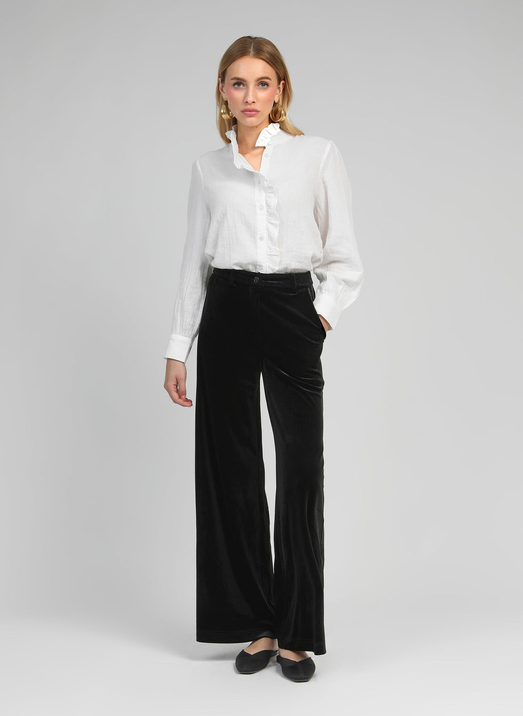 An'ge – Pantalon Pontylane Noir, blond kvindelig model iført en hvid skjorte og sorte fløjlsbukser