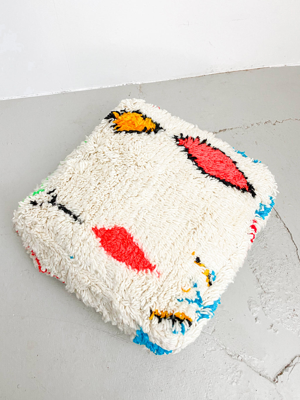 Puf bereber marroquí en crudo con motivos de colores