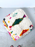 Puf bereber marroquí en crudo con motivos de colores