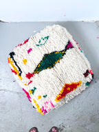 Puf bereber marroquí en crudo con motivos de colores