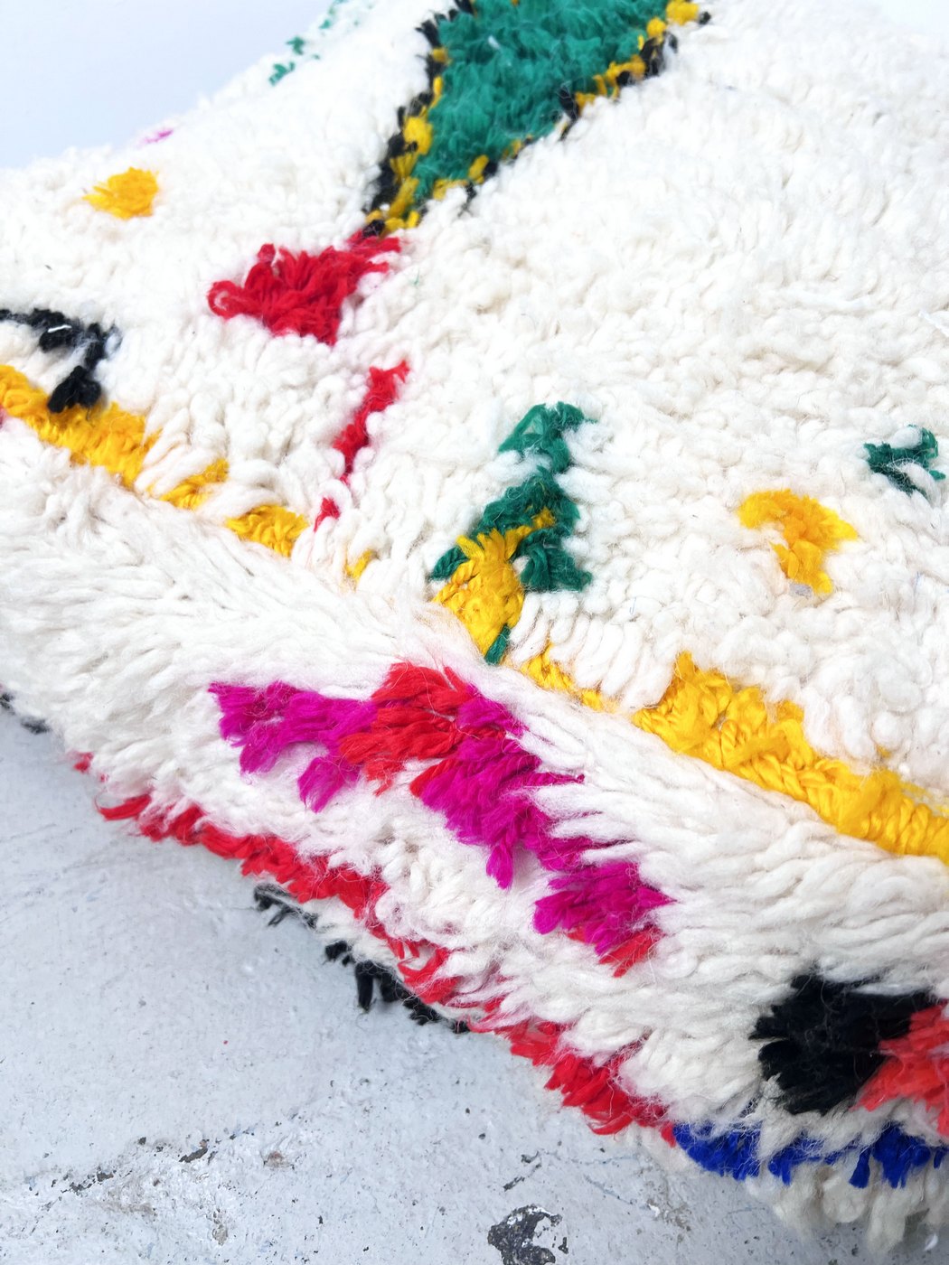 Puf bereber marroquí en crudo con motivos de colores