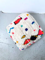 Puf bereber marroquí en crudo con motivos de colores