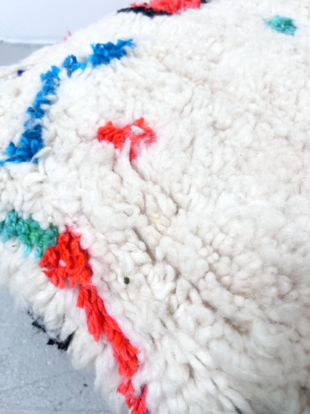 Puf bereber marroquí en crudo con motivos de colores