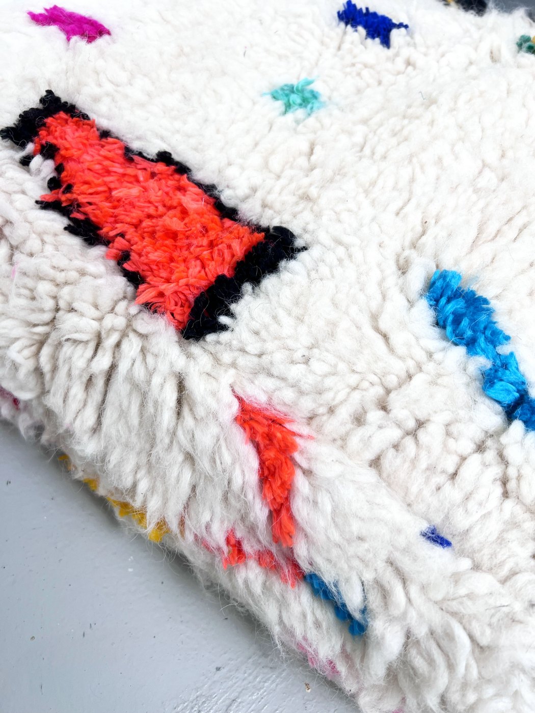 Puf bereber marroquí en crudo con motivos de colores