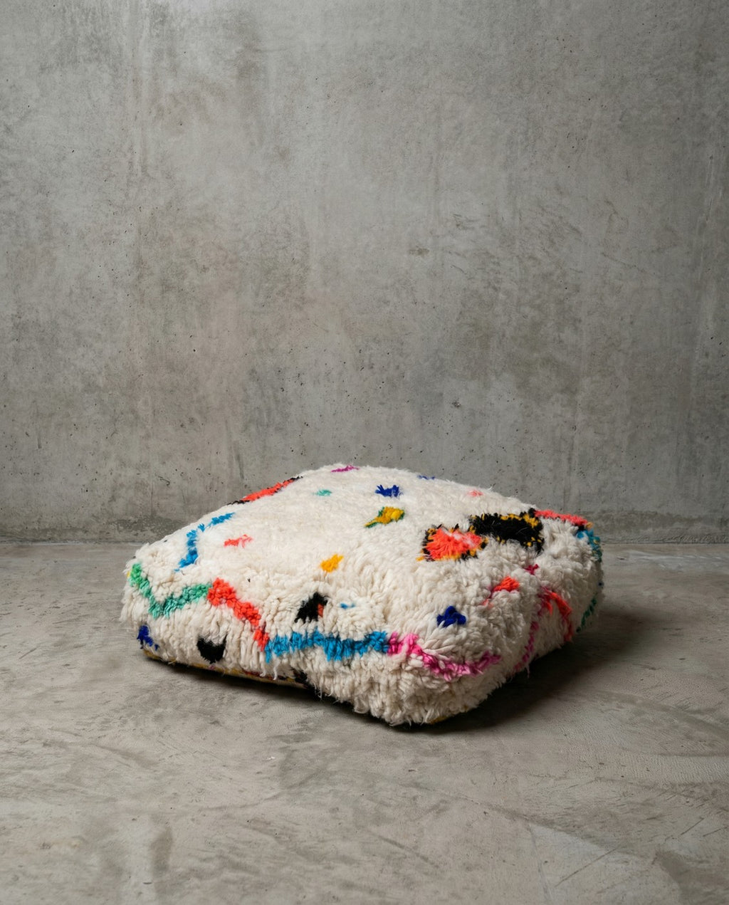 Puf bereber marroquí en crudo con motivos de colores