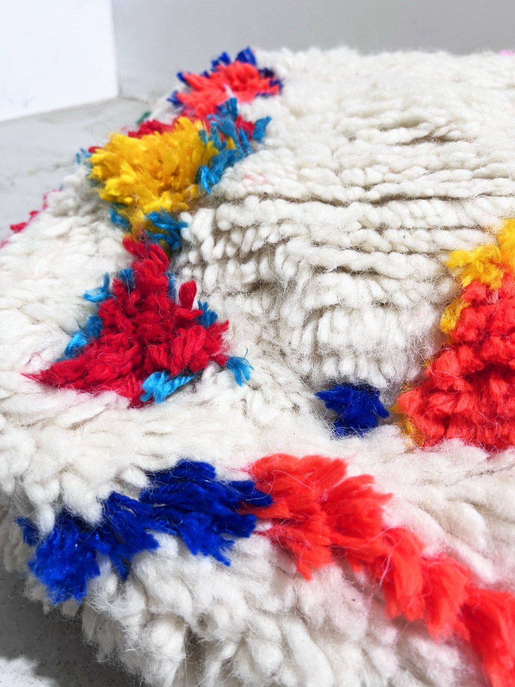 Puf bereber marroquí en crudo con motivos de colores