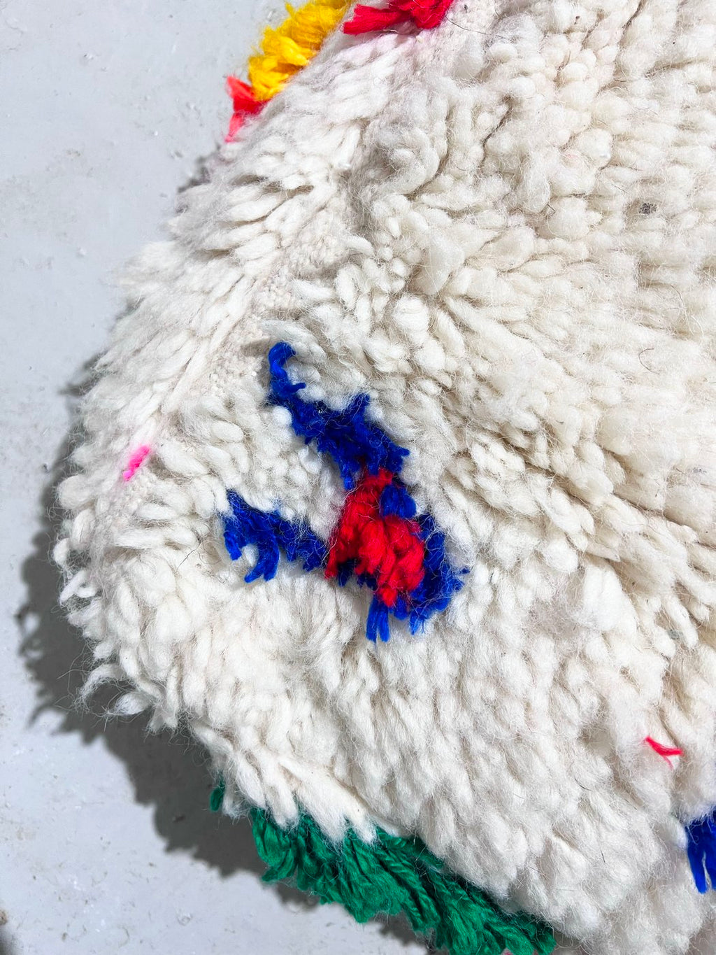 Puf bereber marroquí en crudo con motivos de colores