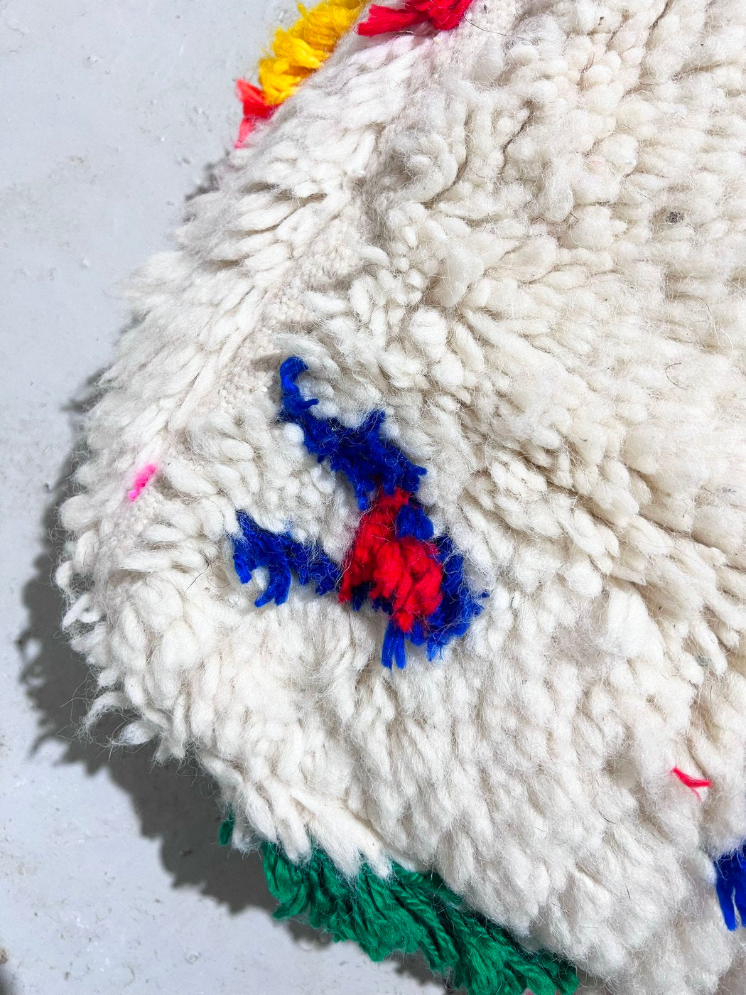Puf bereber marroquí en crudo con motivos de colores