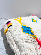 Puf bereber marroquí en crudo con motivos de colores