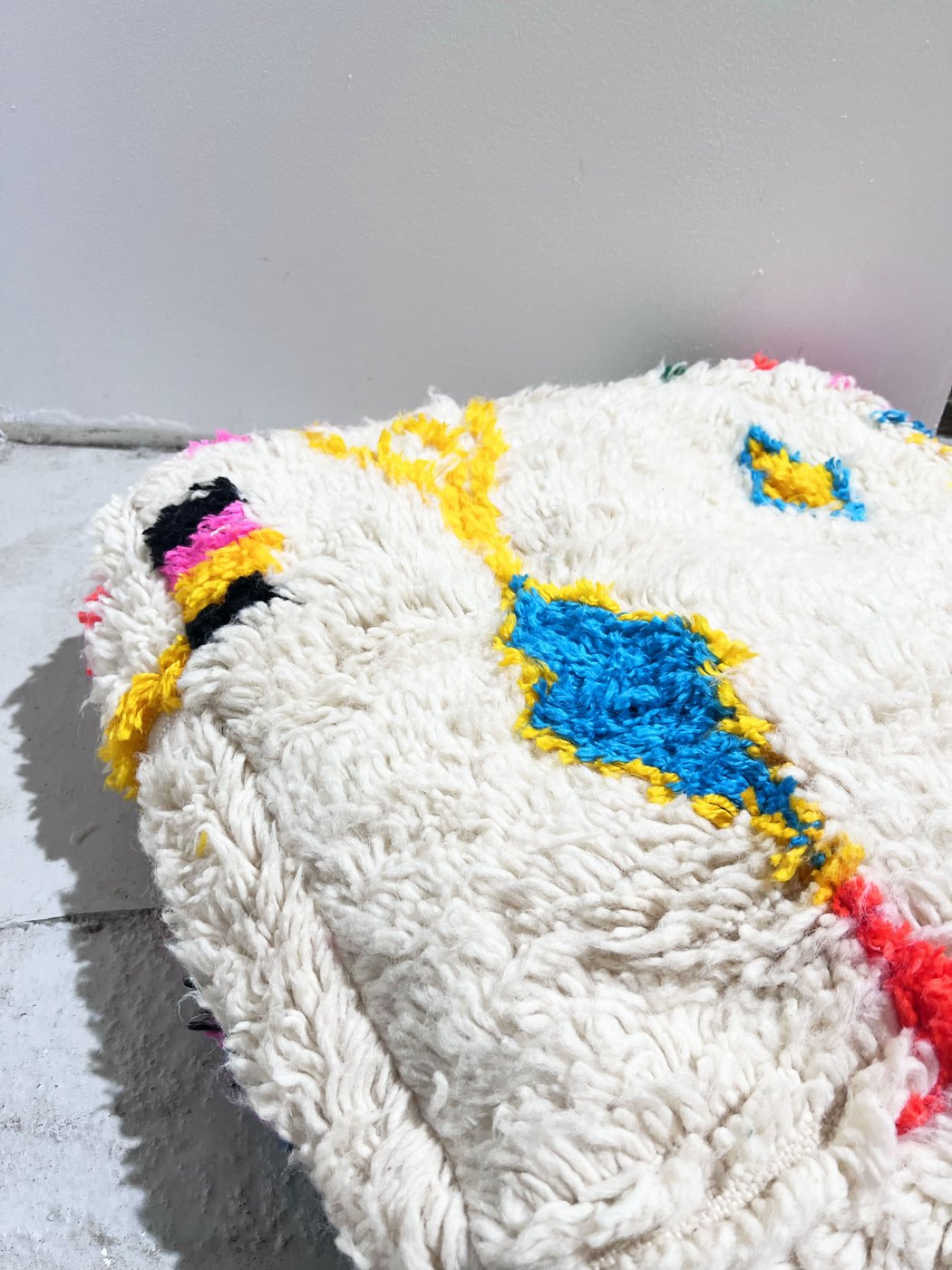 Puf bereber marroquí en crudo con motivos de colores