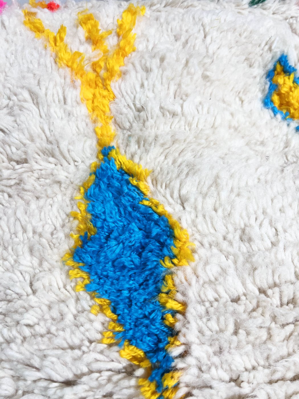Puf bereber marroquí en crudo con motivos de colores