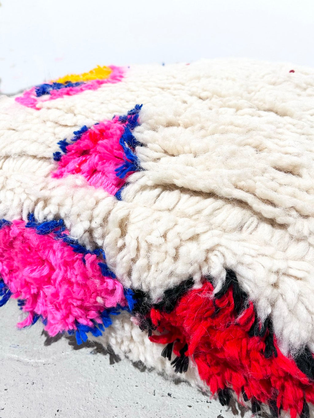 Puf bereber marroquí en crudo con motivos de colores