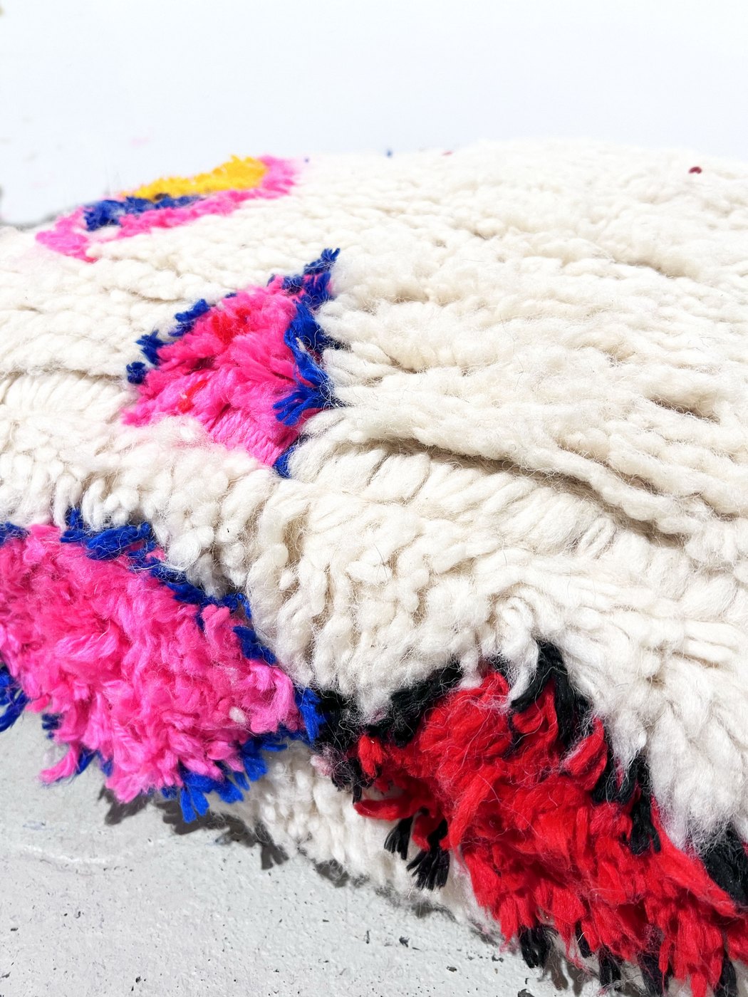 Puf bereber marroquí en crudo con motivos de colores