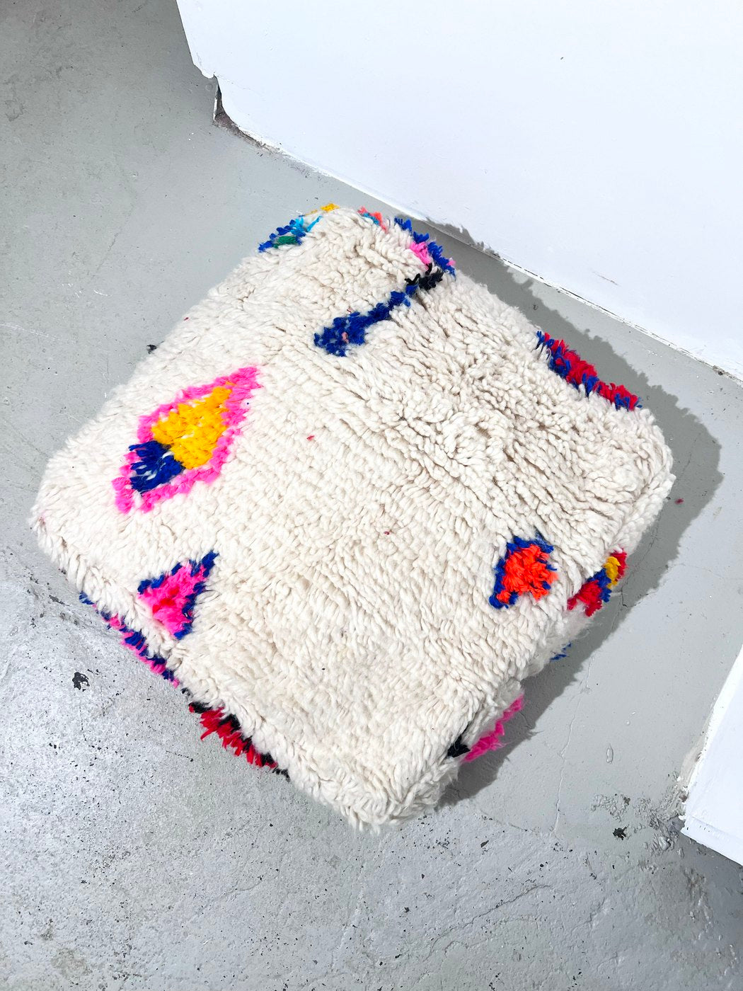 Puf bereber marroquí en crudo con motivos de colores