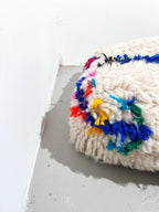 Puf bereber marroquí en crudo con motivos de colores